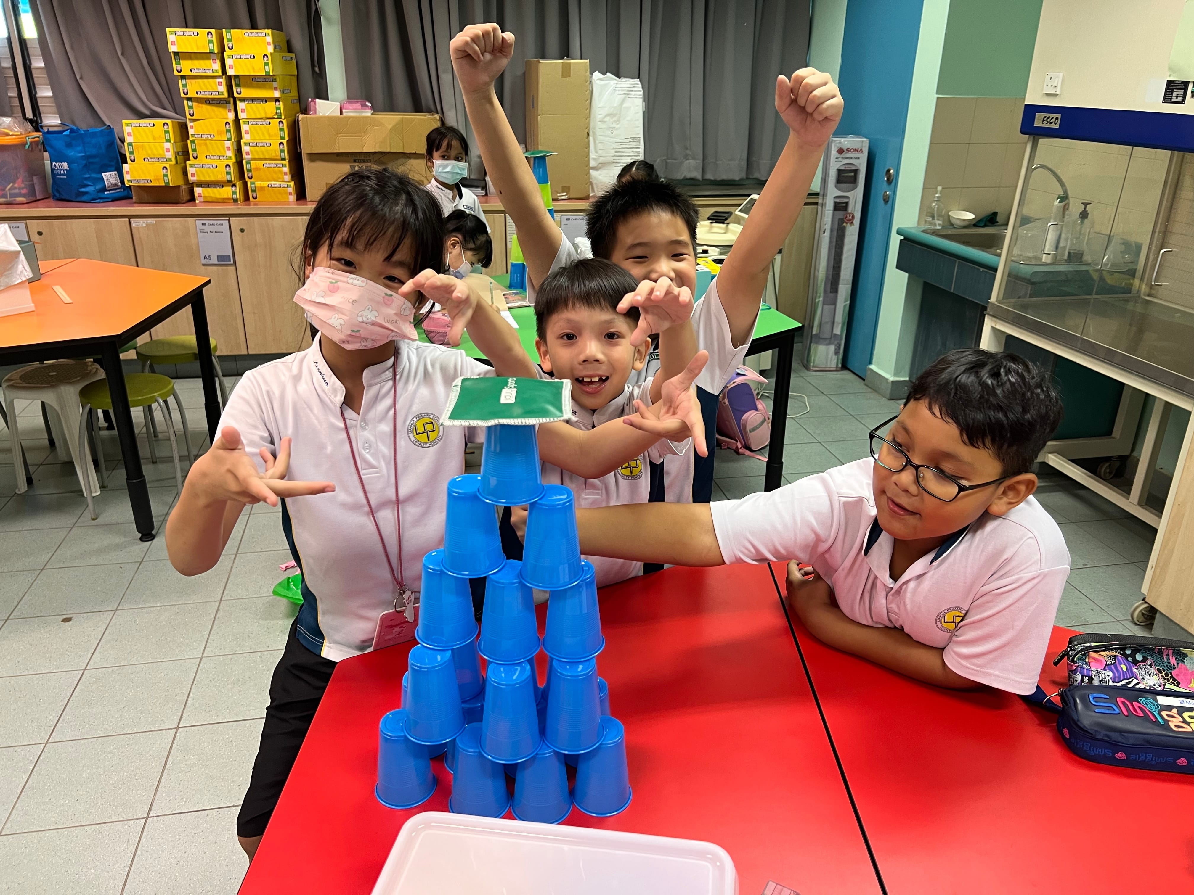 A bunch of students with their cups tower